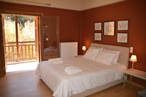 Un dormitorio con una gran cama blanca y una ventana en ZAROUCHLA INN, en Zarouchla