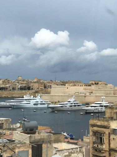 two boats are docked in the water in a harbor at Victoria Flats in Senglea