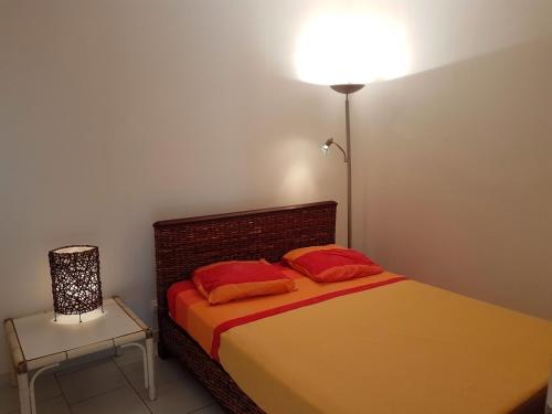 Un dormitorio con una cama con almohadas rojas y una lámpara. en 1 Trova-Ranocchietto en Tucce