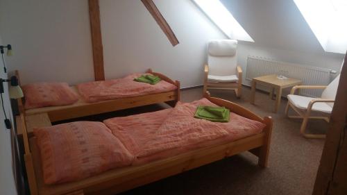 a room with three bunk beds and a chair at Penzion Vanůvecký Dvůr in Telč