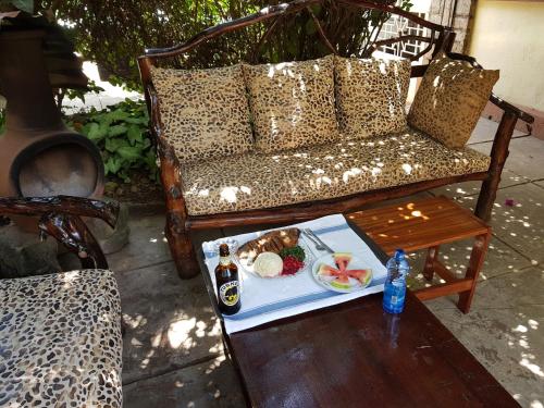 a table with a plate of food on a couch at Karen Little Paradise in Nairobi