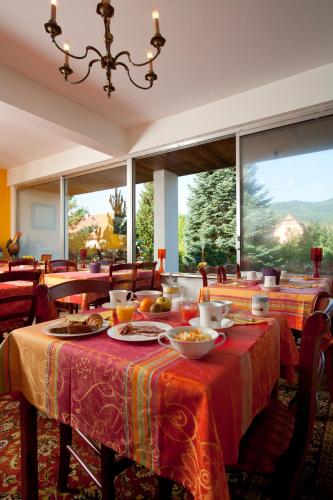 une salle à manger avec une table sur laquelle se trouve de la nourriture dans l'établissement Hôtel Restaurant Logis La Palette, à Wettolsheim