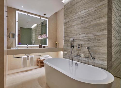 Hyatt Regency Aqaba Ayla Resort في العقبة: حمام مع حوض ومغسلة