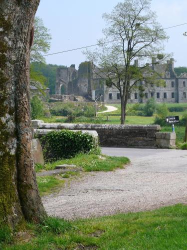 a tree next to a road with a castle in the background at TY GWENN in Laniscat