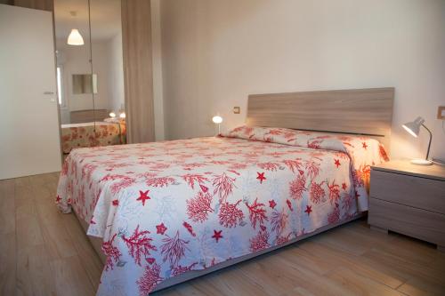 a bedroom with a bed with a red and white blanket at La Contessa Pool & Sea View in Santa Teresa Gallura