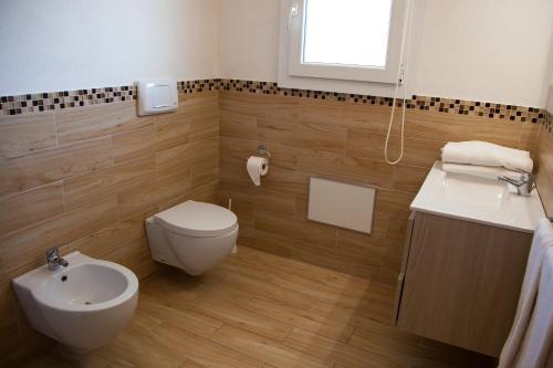 a bathroom with a white toilet and a sink at La Contessa Pool & Sea View in Santa Teresa Gallura