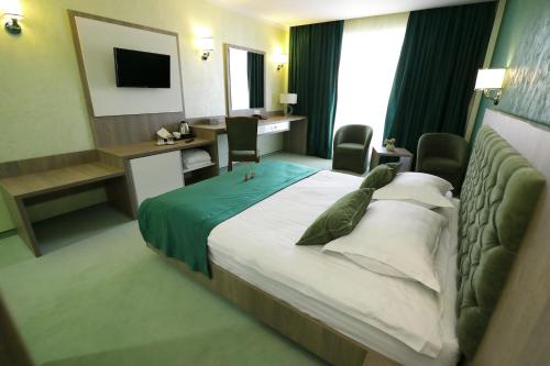 a hotel room with a large bed and a desk at MELISS EVENTS in Craiova
