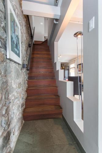 a staircase in a house with wooden floors and a stone wall at Hotel le Priori in Quebec City