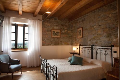 1 dormitorio con 1 cama y 1 silla en una habitación en Alloggio Agrituristico CORTE SAN BIAGIO, en Corno di Rosazzo