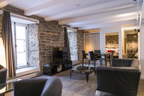 a living room with a couch and a table and chairs at Hotel le Priori in Quebec City