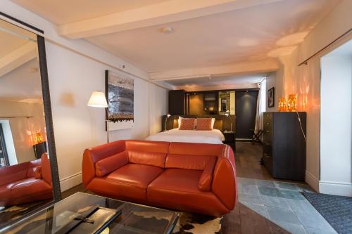 a hotel room with a bed and a couch at Hotel le Priori in Quebec City
