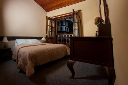 um quarto com uma cama grande e um espelho em Yucay Plaza Inn em Urubamba