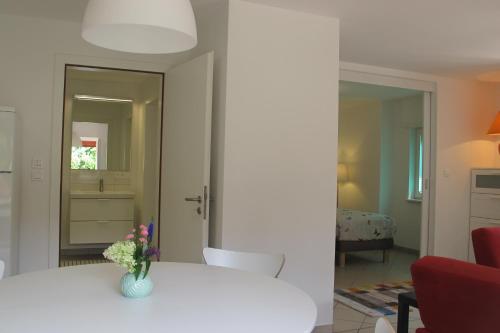 a room with a table with a vase of flowers on it at Gîtes du Tilleul in Niederbronn
