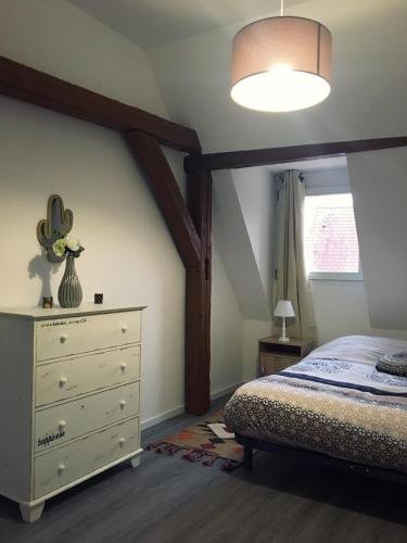 une chambre avec un lit et une commode dans l'établissement L'Ours, à Colmar