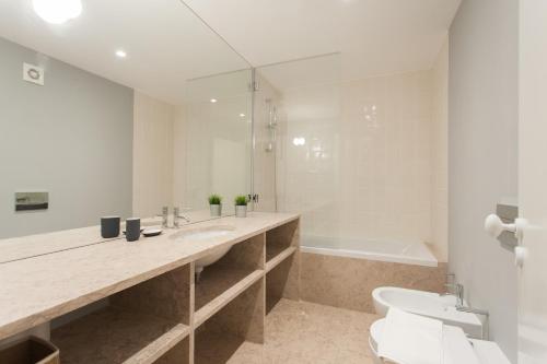 a bathroom with a sink and a toilet and a tub at FLH Principe Real Luxus Apartments in Lisbon