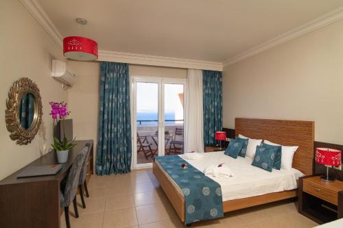 a bedroom with a bed and a table and a window at Sunrise Resort Hotel in Mithymna