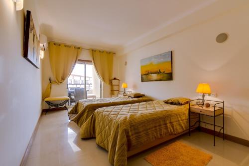 ヴィラモウラにあるAvelãs - Modern apartment - Vilamouraのベッドルーム1室(ベッド2台、窓付)
