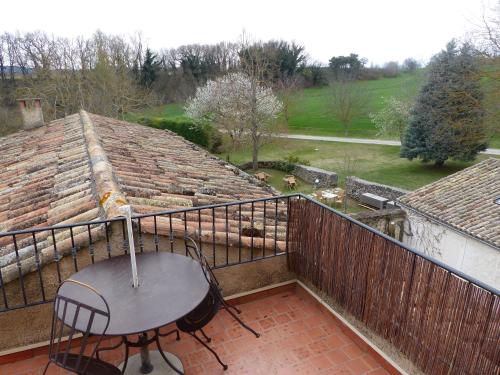 a balcony with a table and chairs on a roof at Charembeau in Forcalquier
