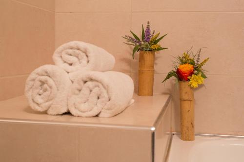 a bathroom with towels and flowers in vases at Sunrise Resort Hotel in Mithymna