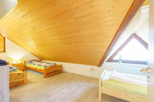 a bedroom with two beds and a wooden ceiling at Ferienwohnung Isabella am Möhnesee in Möhnesee