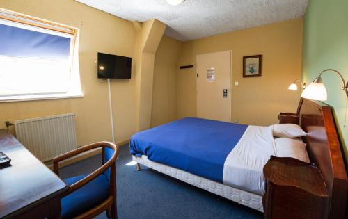 Pokój z łóżkiem, stołem i oknem w obiekcie Hotel de Champagne w mieście Saint-Dizier