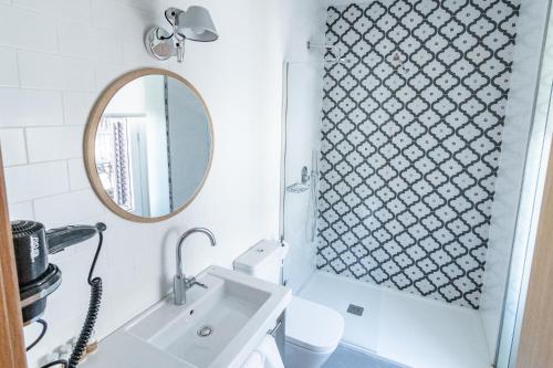 uma casa de banho com um lavatório e um espelho em Plaza Mayor Suites & Apartments em Madrid