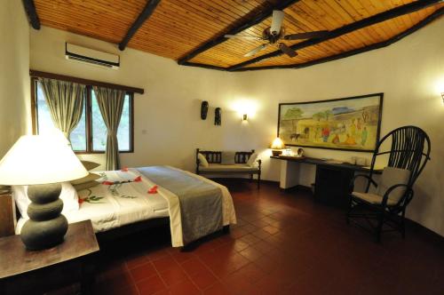 a bedroom with a bed and a desk in a room at Baobab Sea Lodge in Kilifi