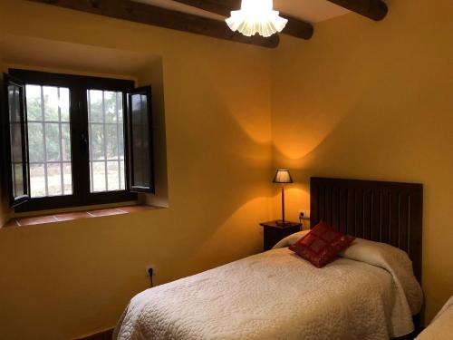 un dormitorio con una cama y una ventana en Cercado Forero, en Cortegana