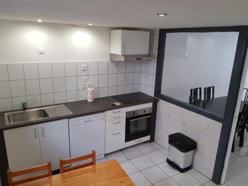a kitchen with white appliances and a table and chairs at Maison meublée 84 mètre carré in Ambérieu-en-Bugey