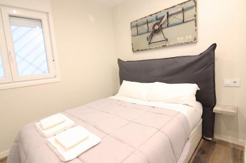 a bedroom with a bed with white sheets and a window at El CONSEJERO de Indias free parking by Cadiz4Rentals in Cádiz