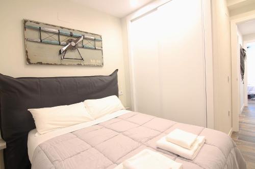 a bedroom with a bed with two towels on it at El CONSEJERO de Indias free parking by Cadiz4Rentals in Cádiz