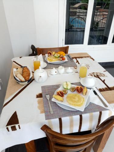 a table with breakfast foods and orange juice on it at Villa Asimba in Kigali