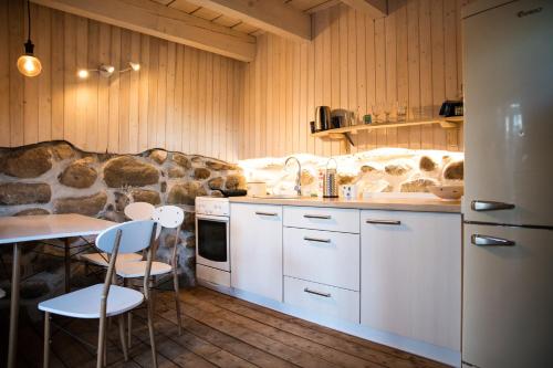 a kitchen with white cabinets and a table and chairs at Pape Rogas in Pape