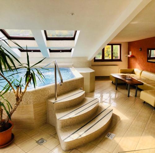 a living room with a swimming pool in the ceiling at Hotel & Penzión Grand Matej in Banská Štiavnica
