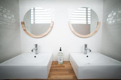 a bathroom with two sinks and two mirrors at Santurcia Hostel in San Juan