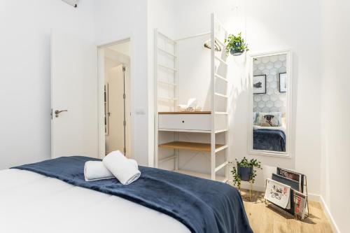 - une chambre blanche avec un lit et une échelle dans l'établissement BNBHolder GRAN VIA es MIA, à Madrid