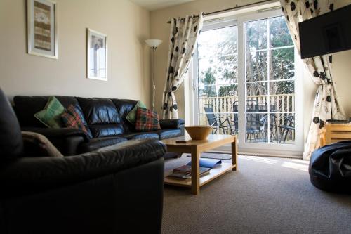 a living room with a couch and a table and a window at Apartment 3, Pheonix Flats. in Portree