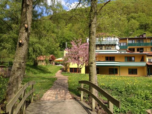 une passerelle devant un bâtiment arboré dans l'établissement Die Hardtmühle, à Bergfreiheit