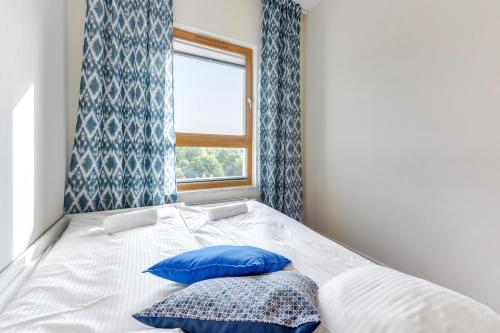 グダニスクにあるProwansja II - Mila Balticaのベッドルーム1室(青いカーテン、窓付)