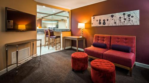 a living room with a red couch and a bar at Best Western Plus Casino Royale - Center Strip in Las Vegas