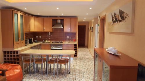 a kitchen with wooden cabinets and a island with bar stools at Apartamento Altura II in Altura