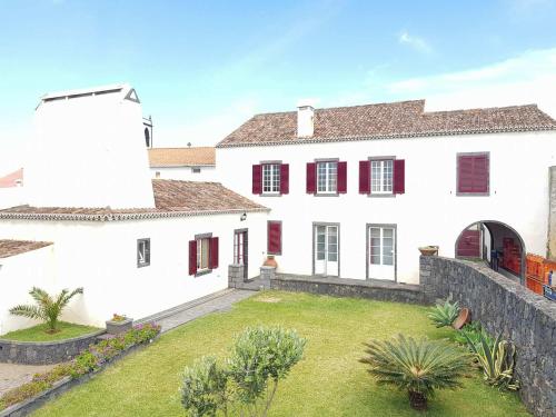 a white house with a lighthouse in a yard at Home Sweet Home in Ribeira Grande
