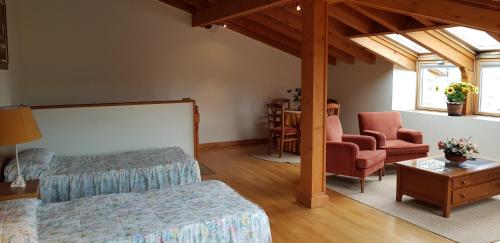 オヨス・デル・エスピーノにあるCasa Rural Tío Carlillosのベッドルーム1室(ベッド1台、椅子、テーブル付)