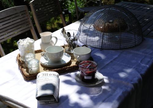 セヴェラック・ル・シャトーにあるMaison d'Hôtes La Singulièreの青いテーブルクロスがかけられたテーブルとカップ