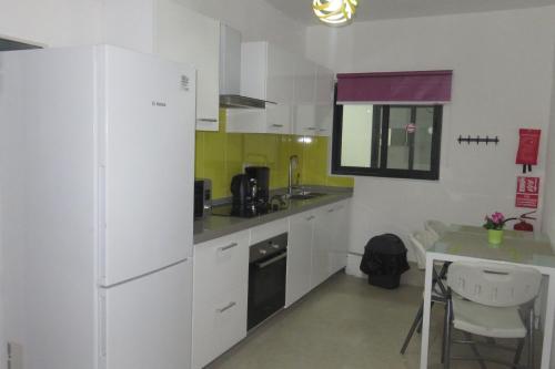 a kitchen with a white refrigerator and a table at Ibis Tourist Residence 1 in Mahébourg