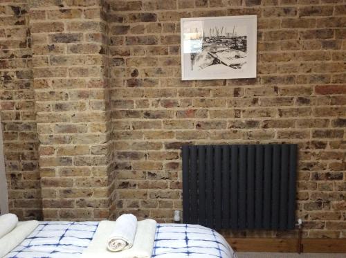 a brick wall with a bed in a room at Passengers House in Whitstable