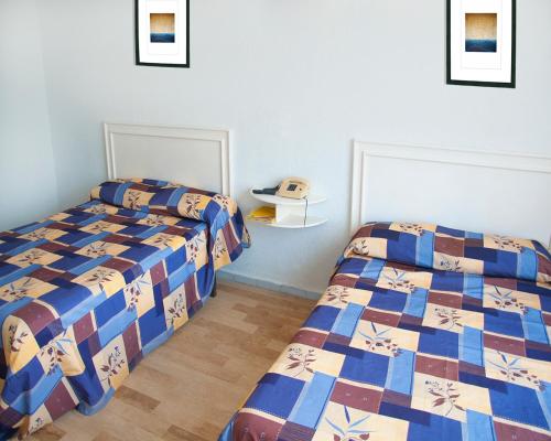 two beds in a room with two beds sidx sidx sidx sidx at Dorados Acapulco in Acapulco