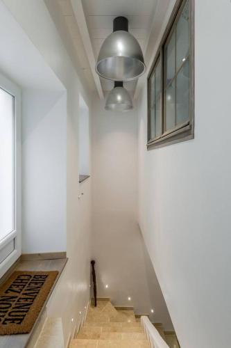 un couloir avec un mur blanc et une fenêtre dans l'établissement Petite Maison du Ventoux, à Mormoiron