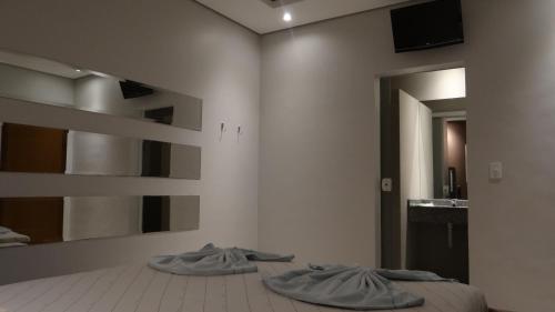 sypialnia z 2 poduszkami na łóżku i lustrem w obiekcie Delirio Moteis Pousada w mieście Dourados