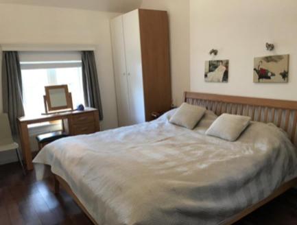 a bedroom with a bed and a desk and a window at Flora Cottage in Guildford